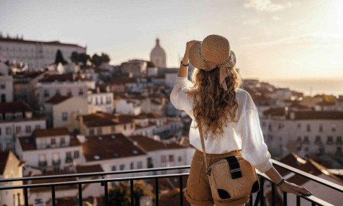 Blonde woman standing on the balcony and looking at coast view of southern Madrid