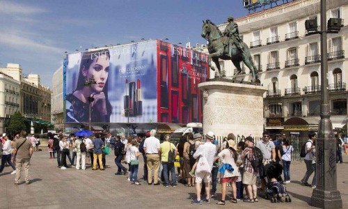 Tourists walk on the Puerta del Sol square near the statue in Madrid, Spain.